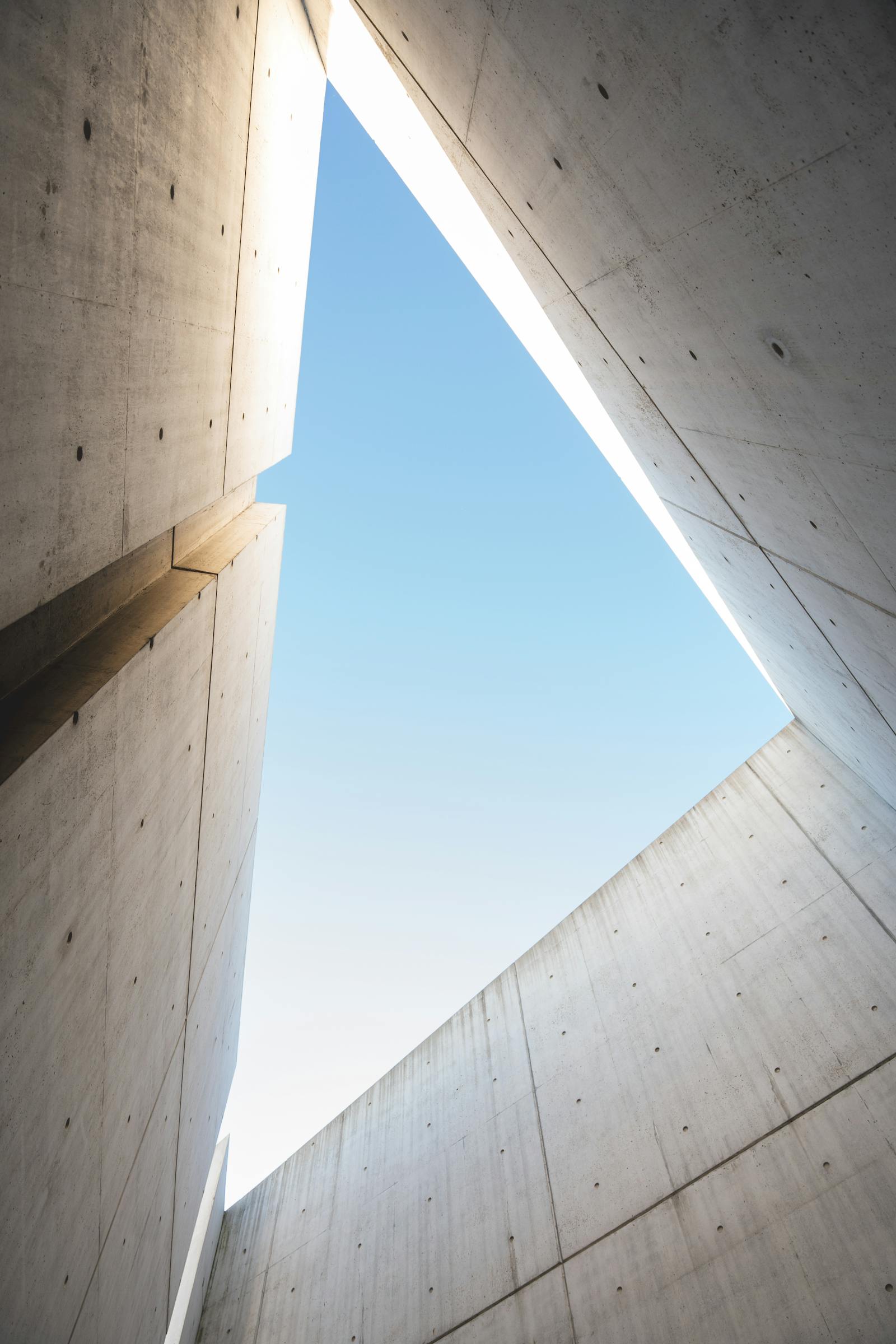 Modern concrete walls framing a triangular view of the sky