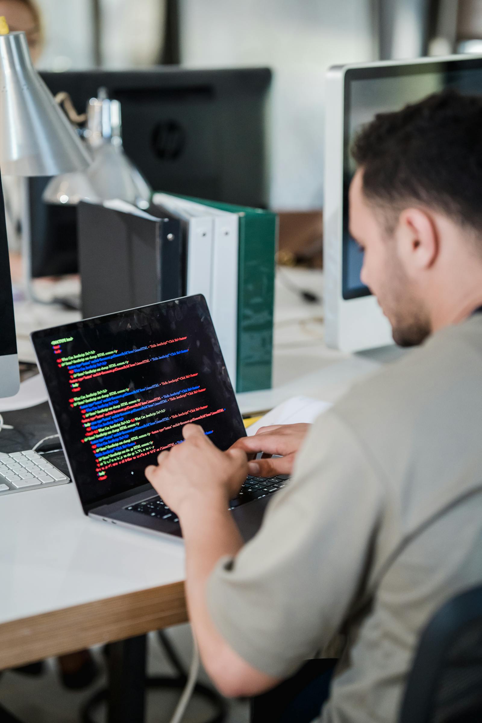 A focused software developer typing code on a laptop