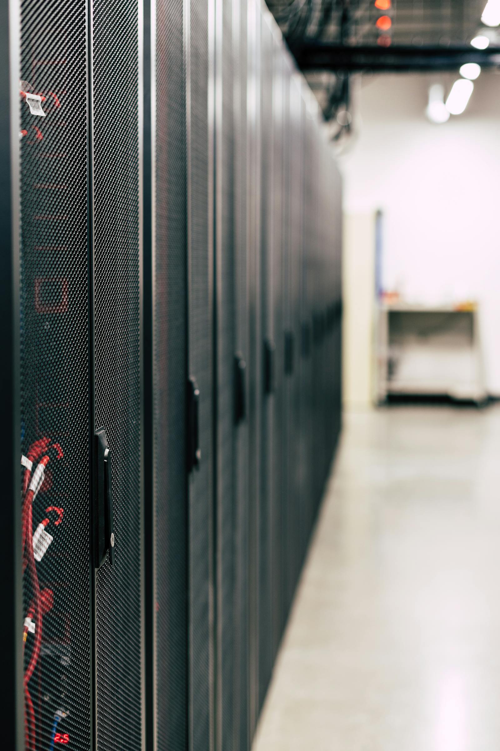Black server cabinets with red network cabling in a data centre