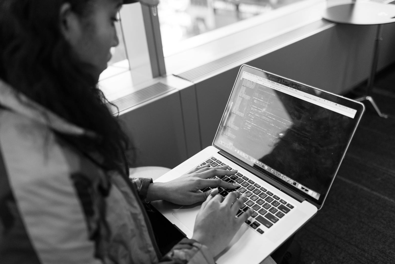 A woman working at a laptop in a contemporary indoor environment