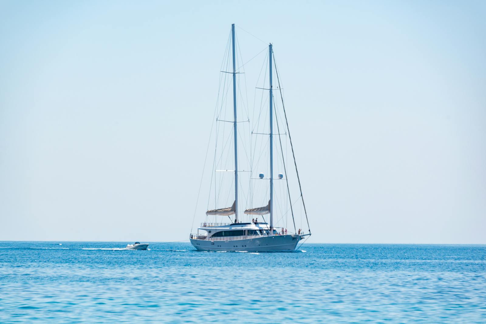 An elegant sailing yacht with masts on calm blue water