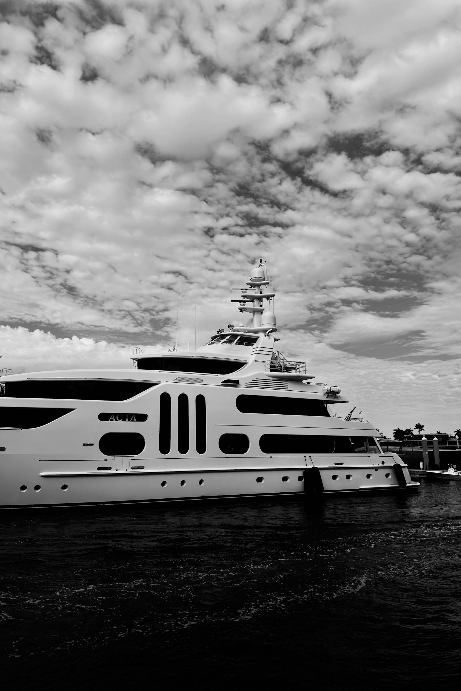 A modern luxury motor yacht photographed against a dramatic sky